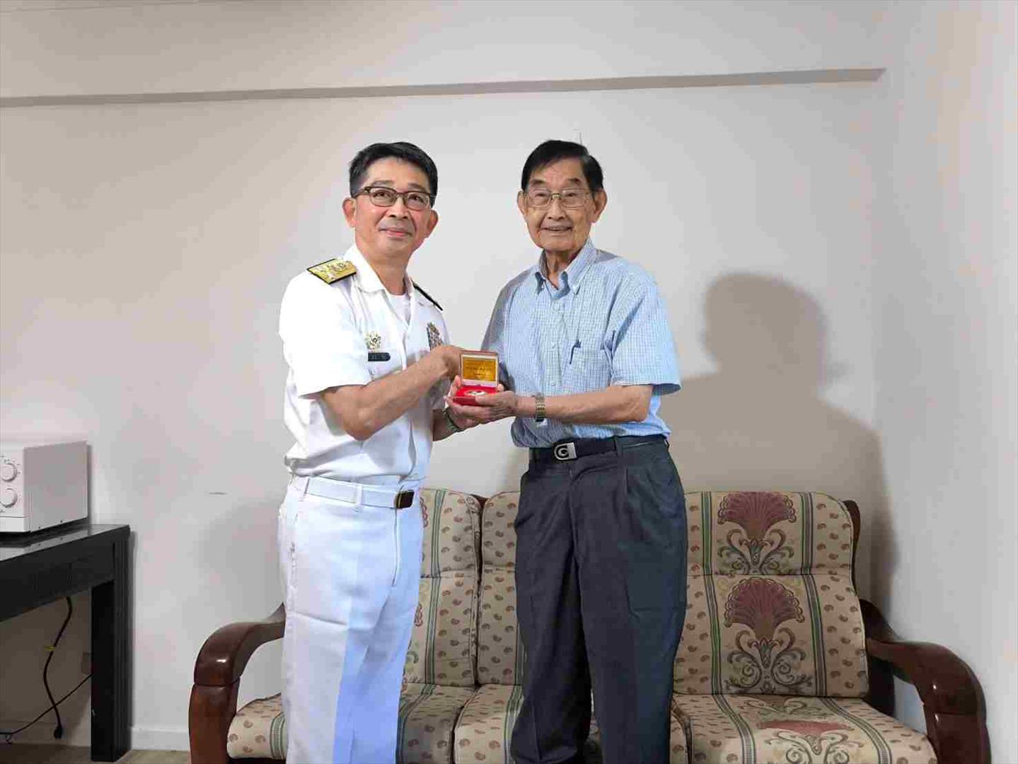 海軍司令部副司令敖以智中將（左）致贈榮民萬正啟 （右）「二戰暨抗戰勝利八十週年」紀念徽章