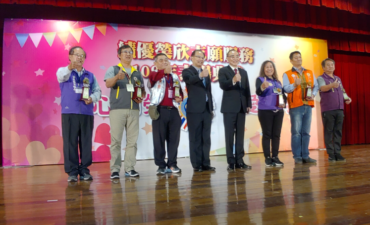 陳鷺禾先生（左）榮獲本會109年績優社區志願服務組長接受馮世寬主任委員（右4）頒獎表揚。