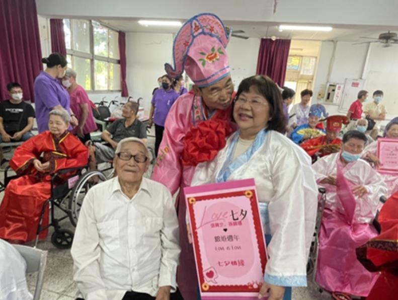 112年8月22日張興罡夫婦婚齡雖28年，參與榮家舉辦「幸福七夕重溫美好時光」活動，邀請百歲楊俊全伯伯（左）當他的家長一同走紅毯。
