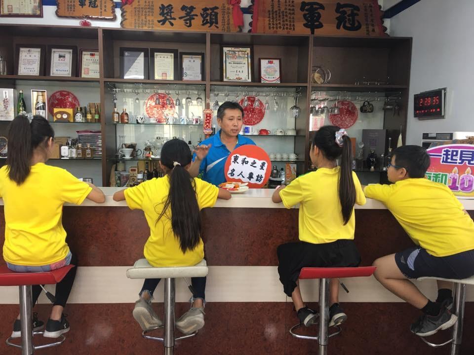 陳俊源先生（站立者）與國小學弟妹分享創業經驗。