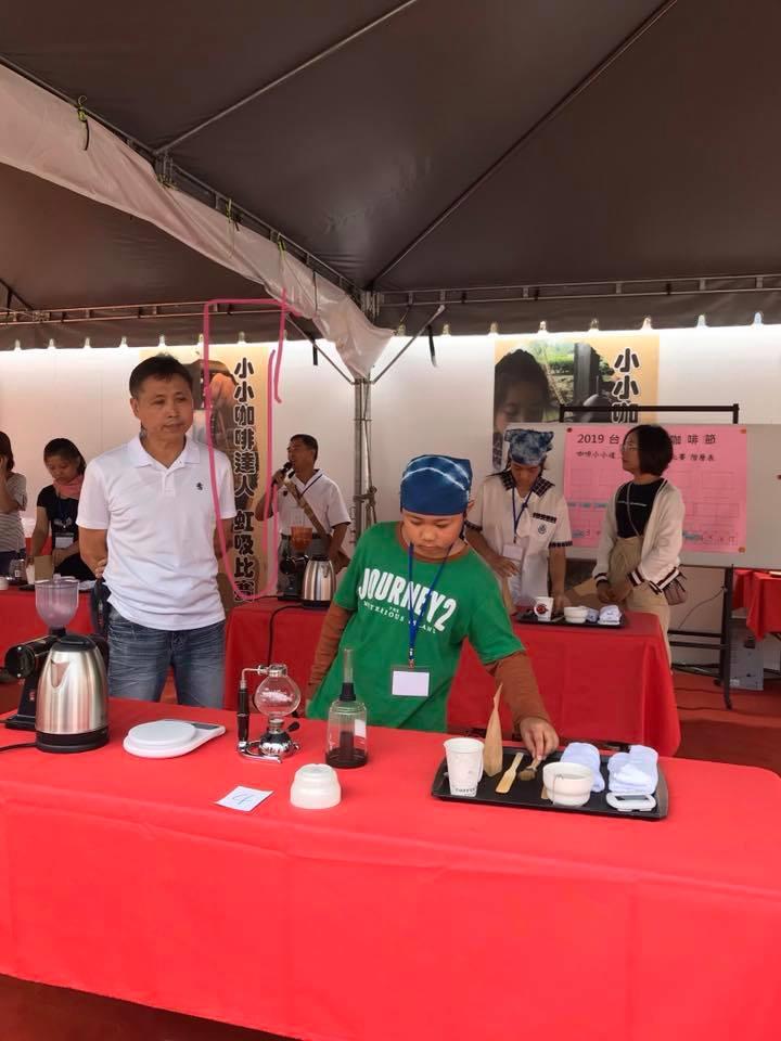 陳俊源先生（左，站立者）擔任2019年台灣國際咖啡節小小咖啡達人虹吸比賽講師。